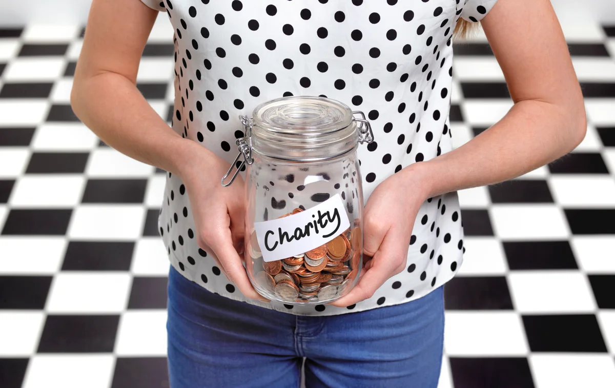 Girl holding a donation jar with coins