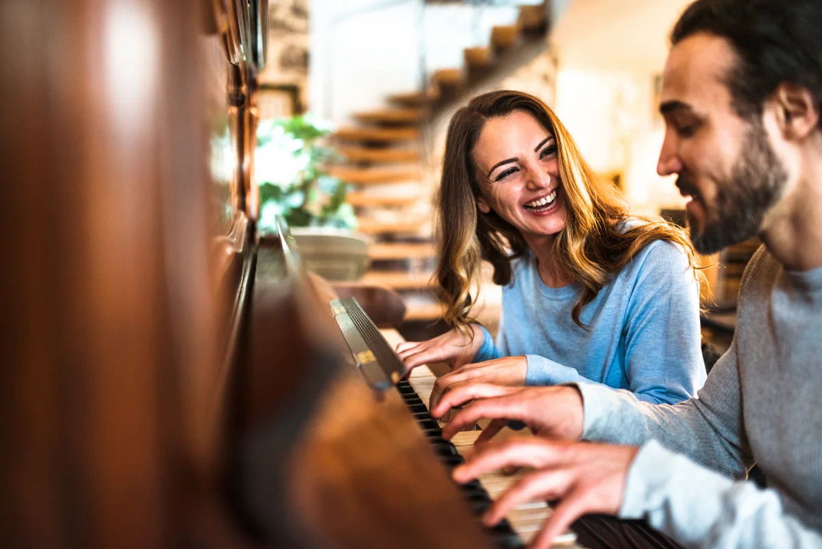 Woman and man playing piano together