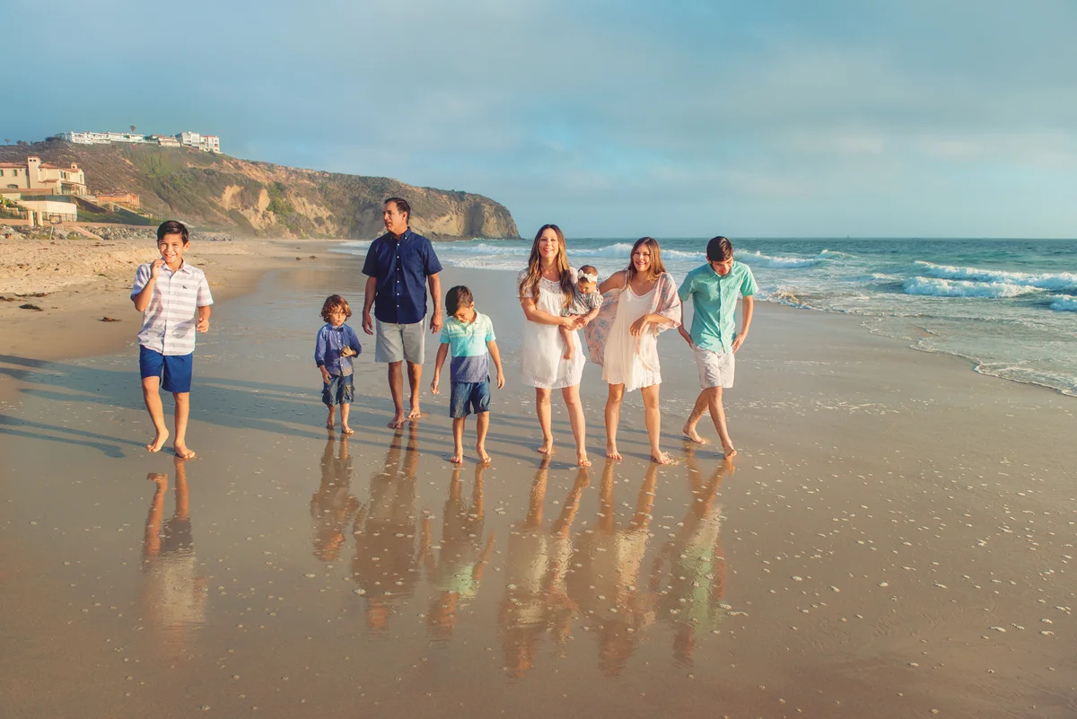 Large blended family walking on beach