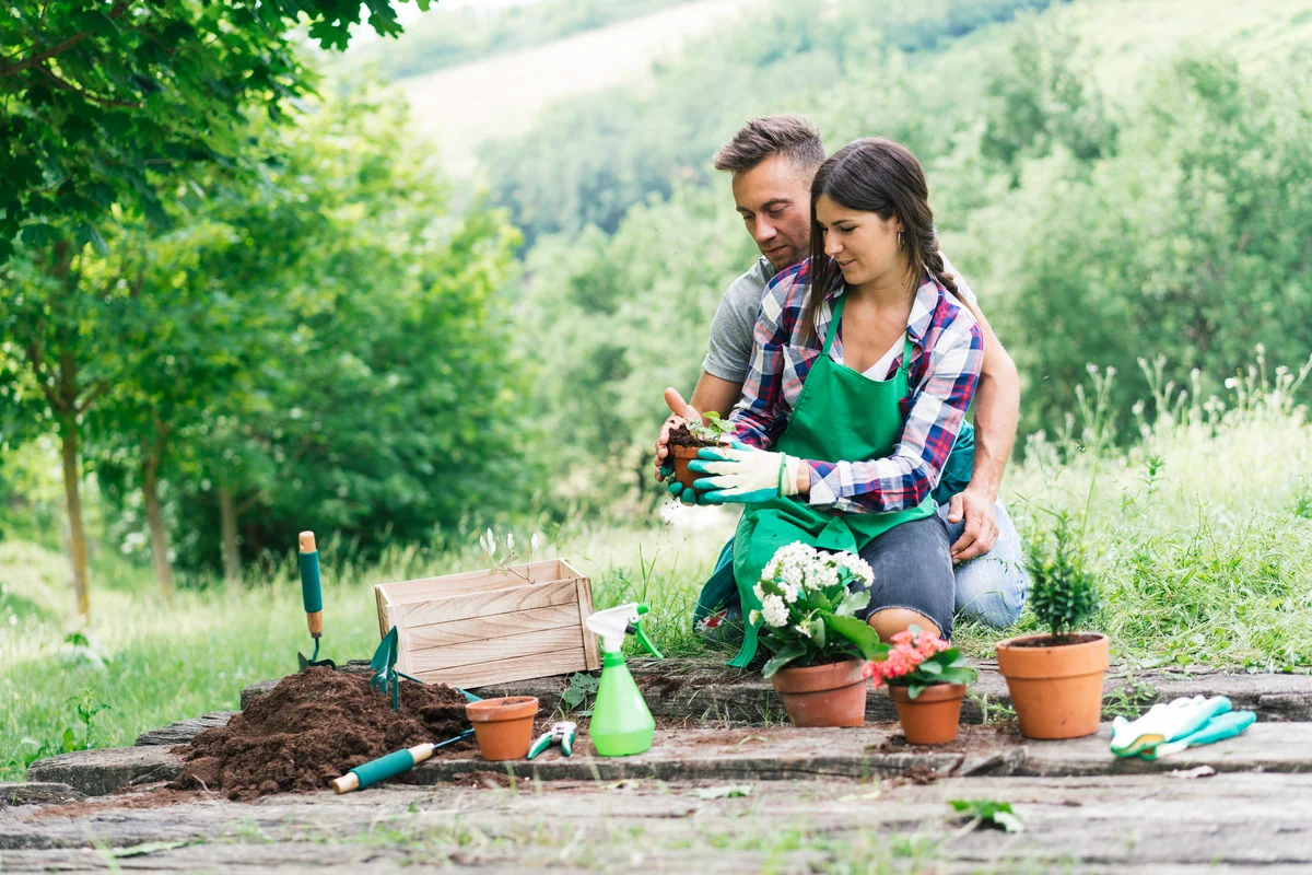 Man and woman repotting plants and enjoying each other