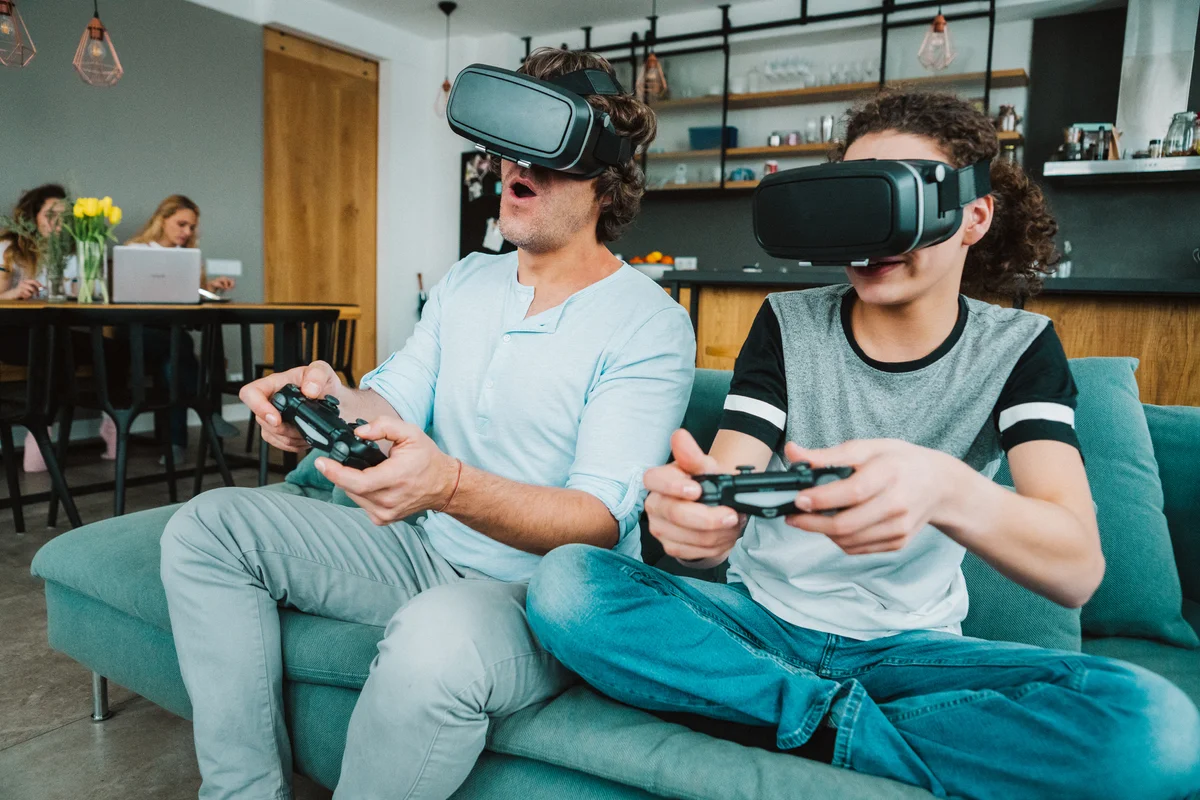 Father and teenage boy playing VR game