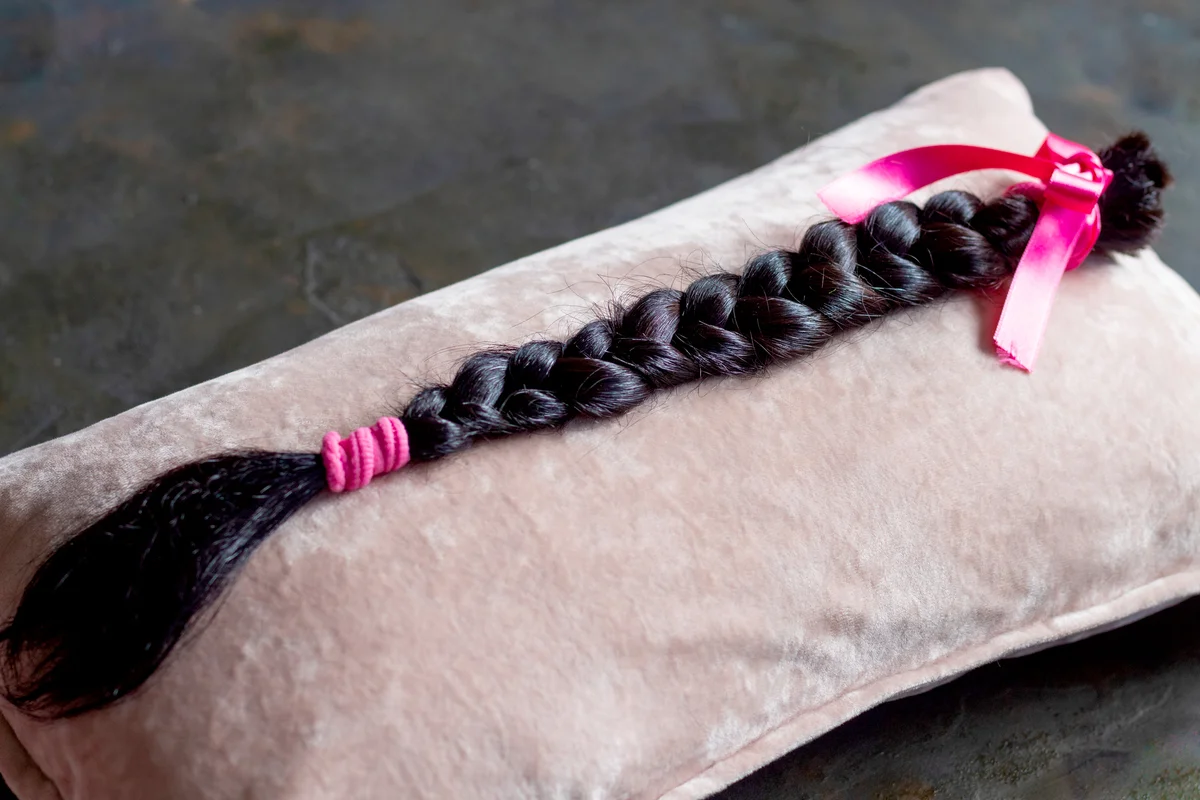 Brown hair braid on pink background for hair donation for women