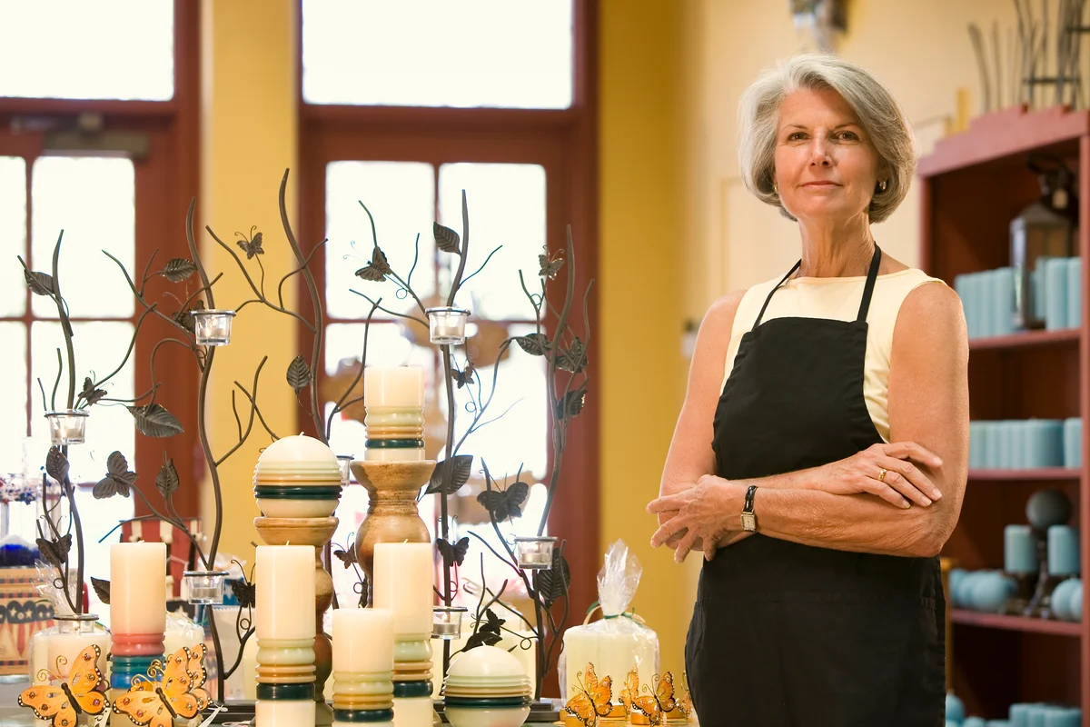 Shop owner standing in front of candle display