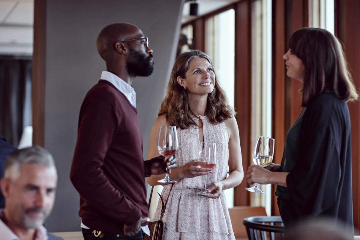 Colleagues talking while enjoying drinks in party after work