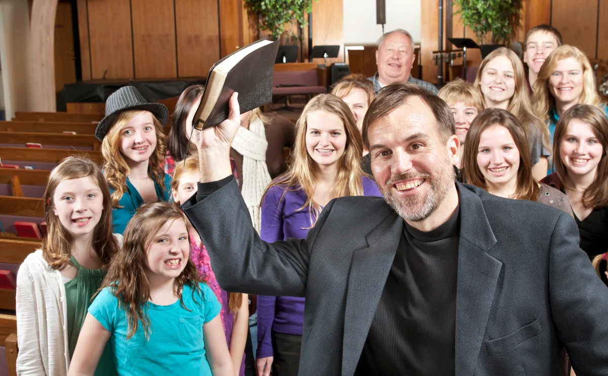 Pastor holding Bible with youth group