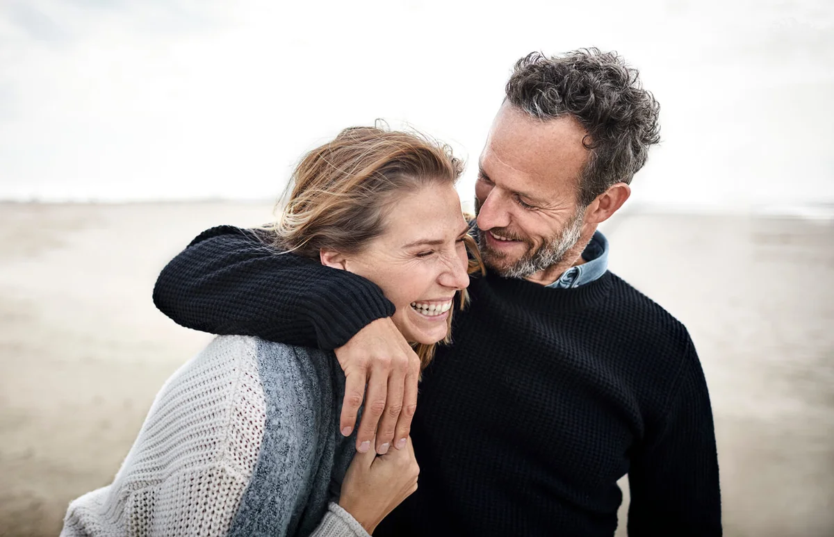 Happy couple hugging on the beach