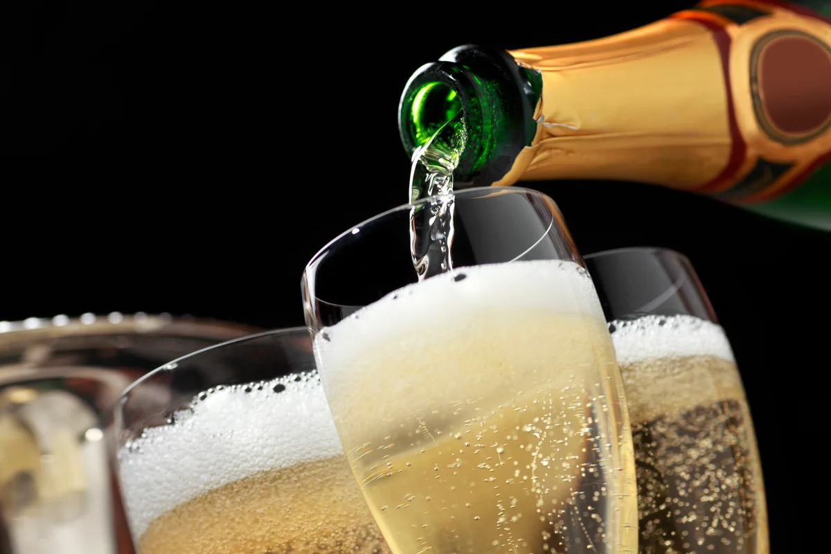 Pouring champagne into fluted glasses