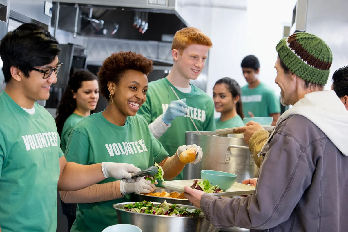 Volunteers working in a kitchen serving out food