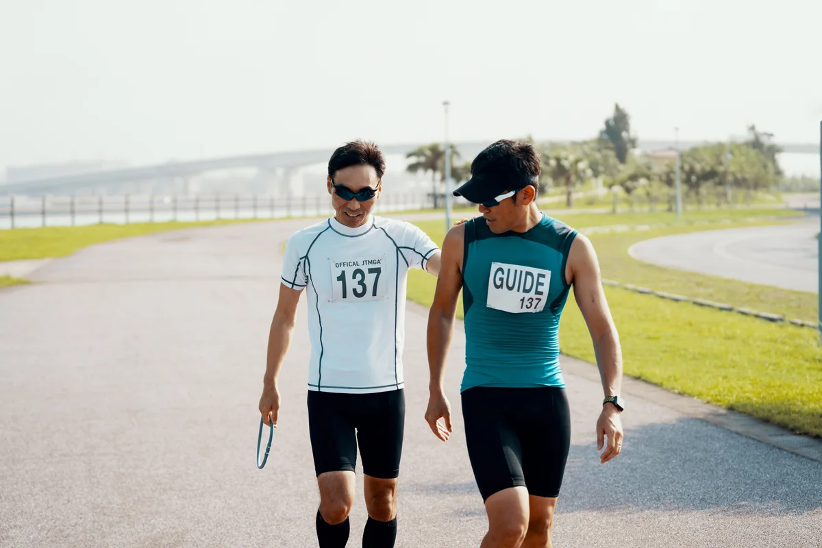 Blind triathlete and guide walking on track