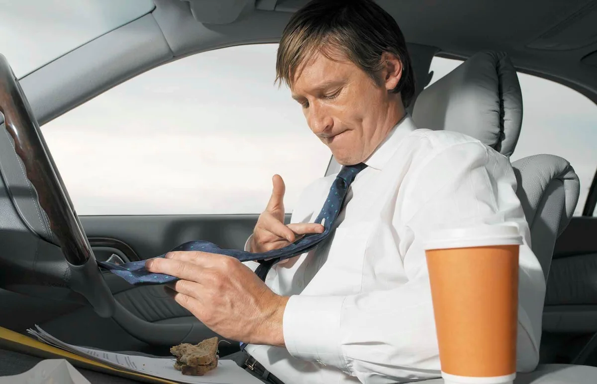 Mature businessman having lunch in car