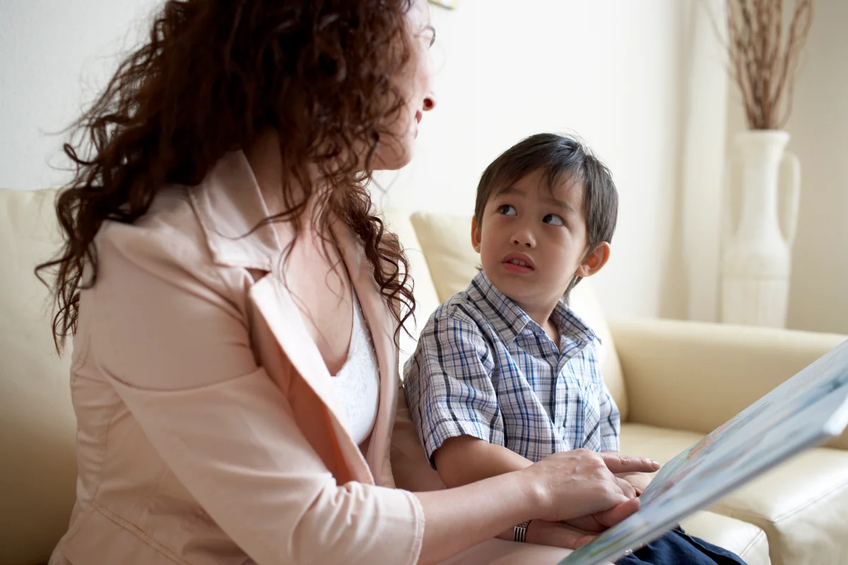 Mom comforting son while reading book