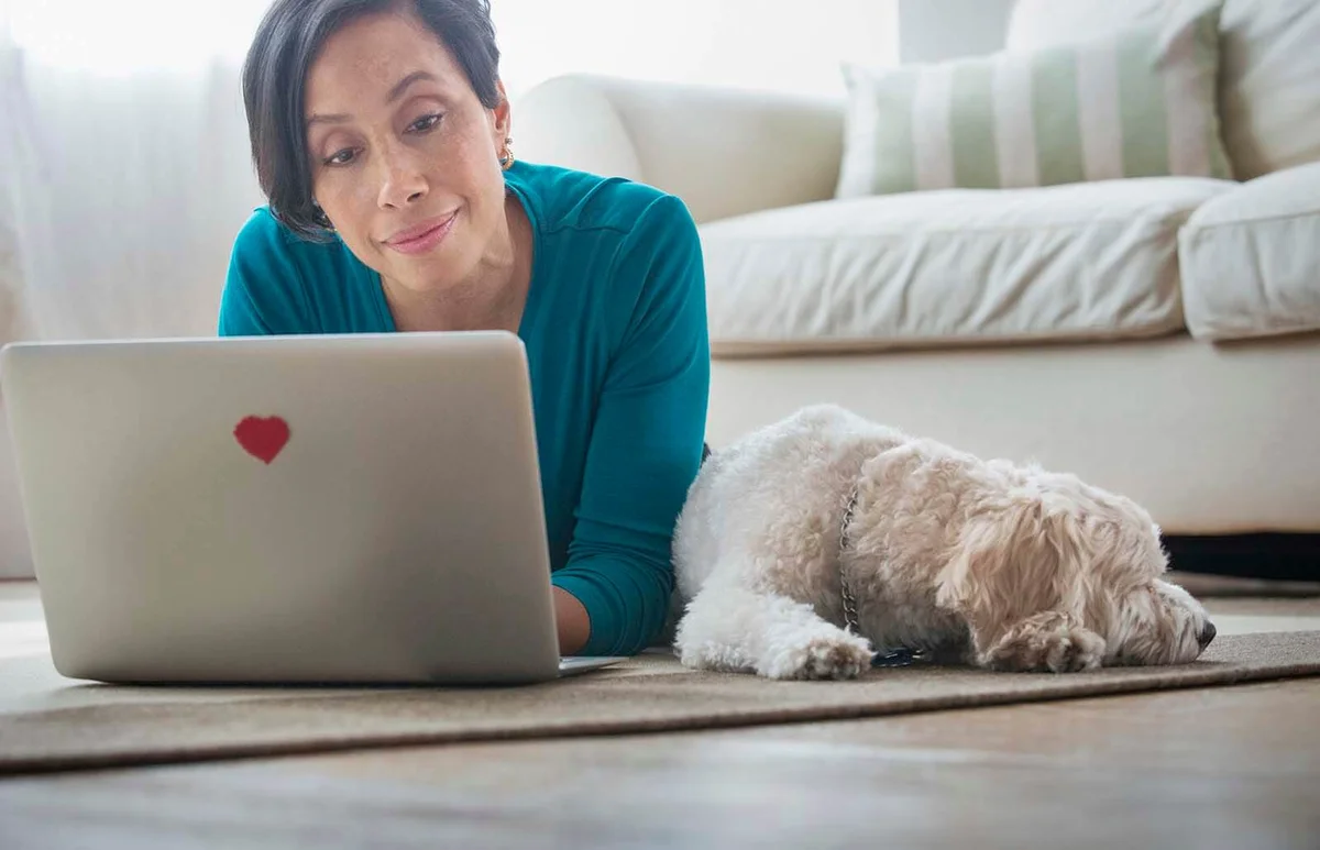 woman using laptop with dog