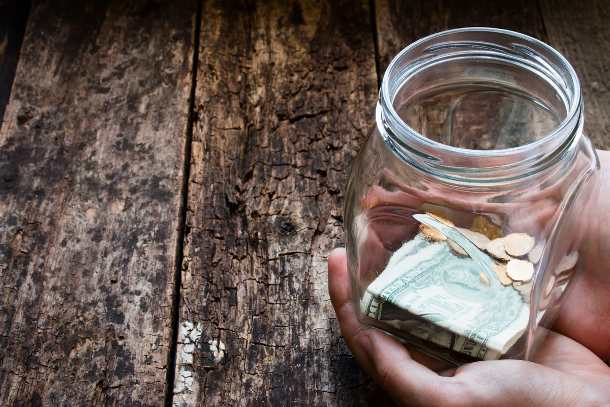 Man holding donation jar with money