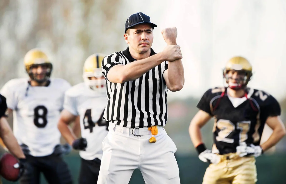Referee showing the illegal use of hands signal