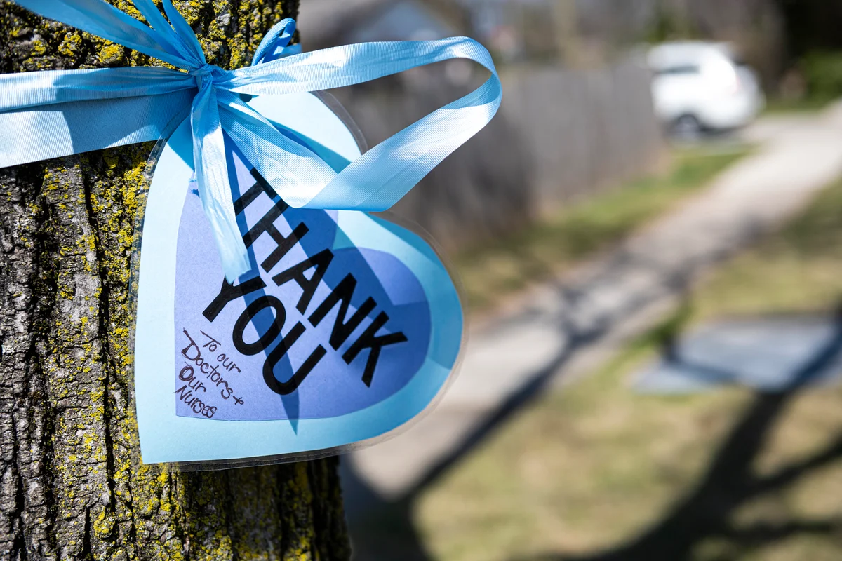 Blue Thank-You sign with blue ribbon wrapped around tree
