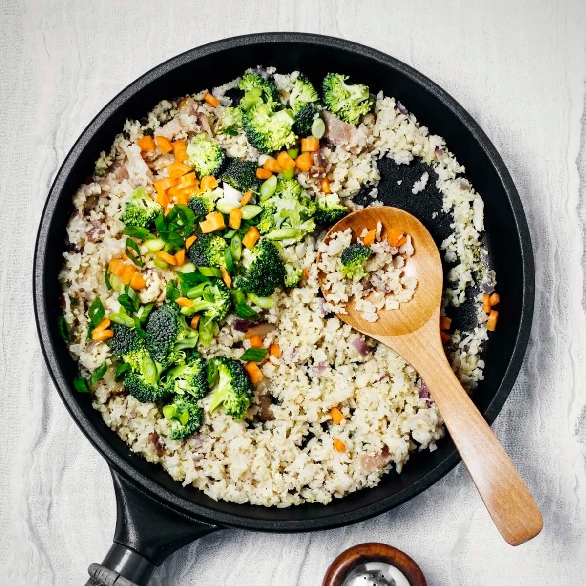 Fried rice with green onion and broccoli in a skillet