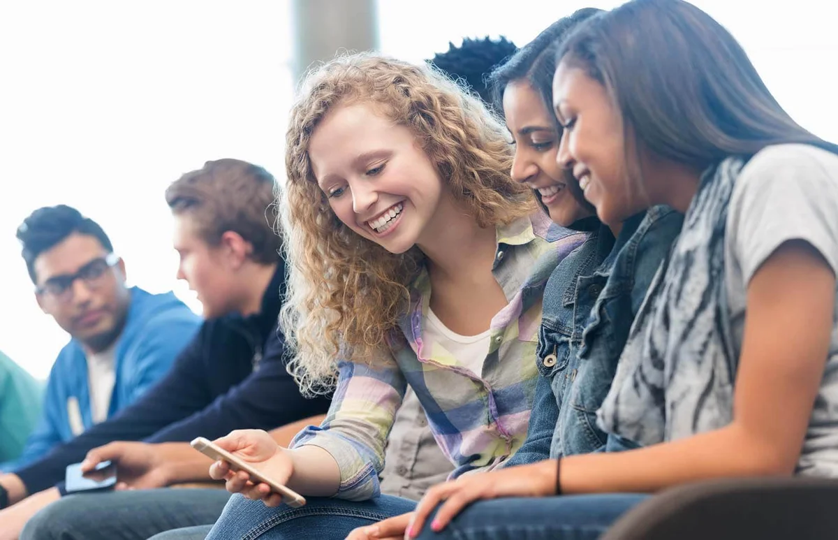 Group of teen girls looking at smart phone together