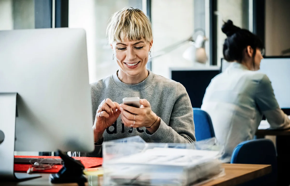 business woman with smart phone sitting on desk