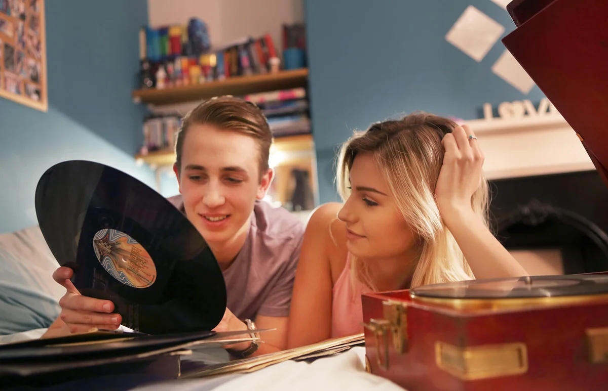 Young couple in bedroom with record player