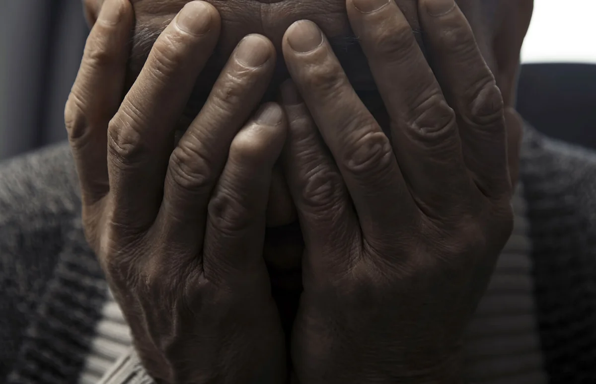 man covers his face with hands in despair