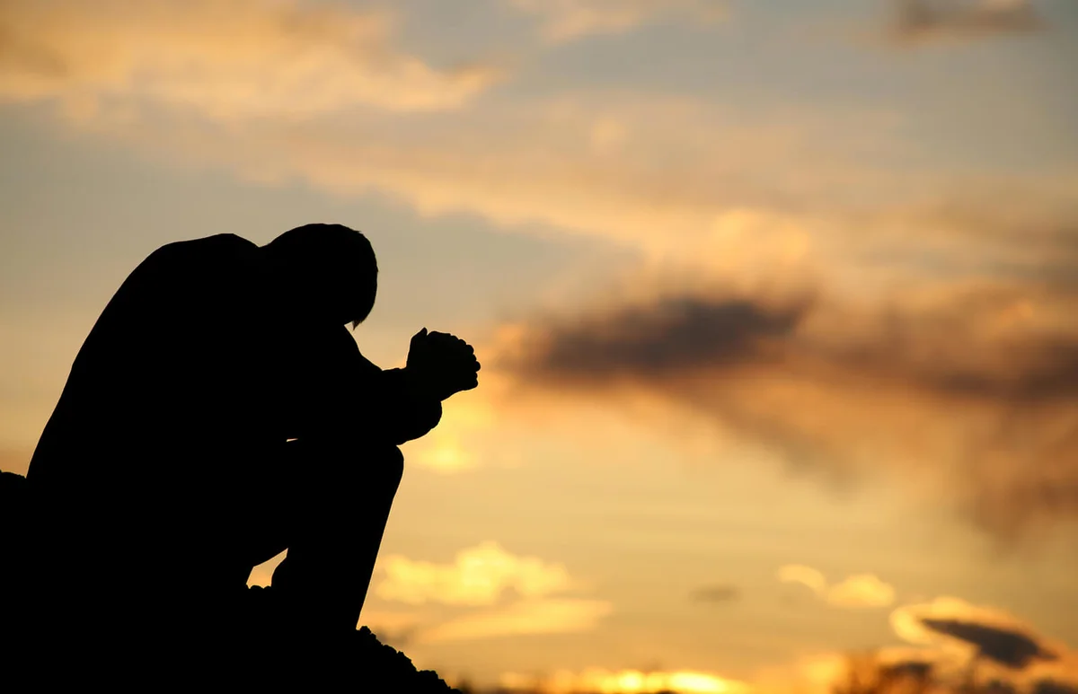 Silhouette of Unrecognizable Man Meditating Outside