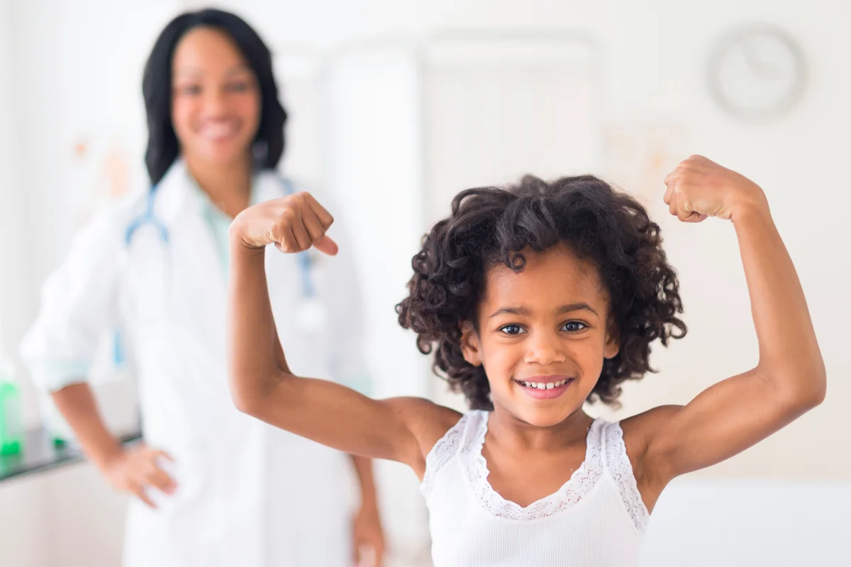 Girl flexing muscles in doctor's office
