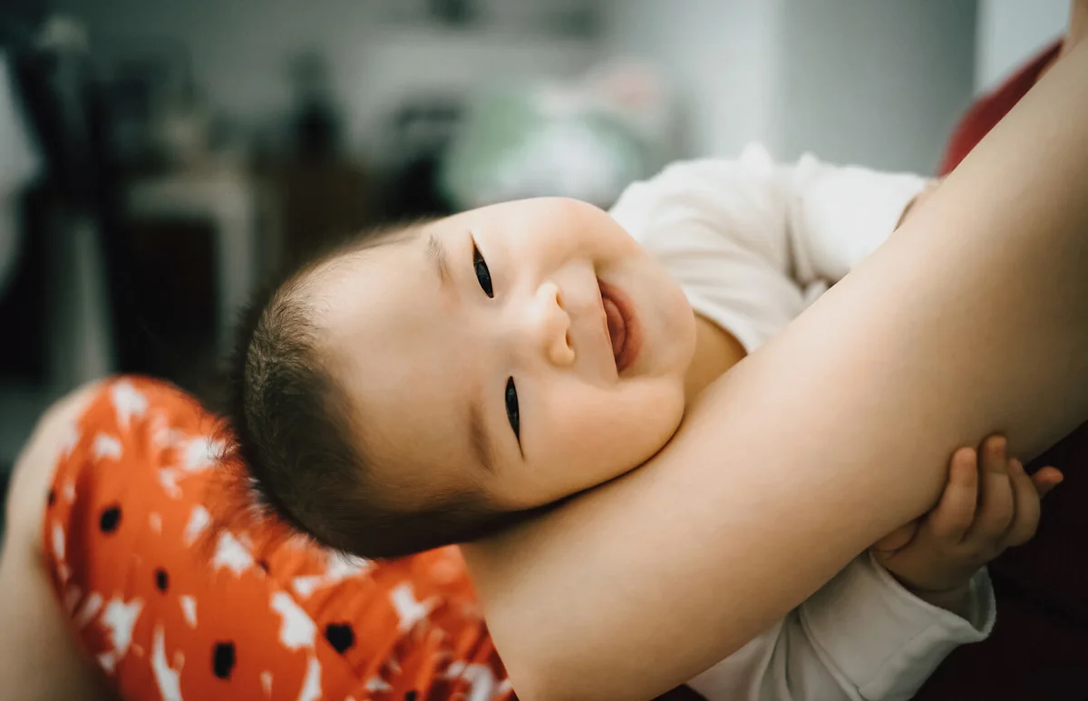 Mother embracing smiling cute baby in her arms