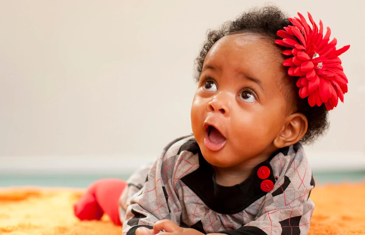 baby girl with red flower in her hair