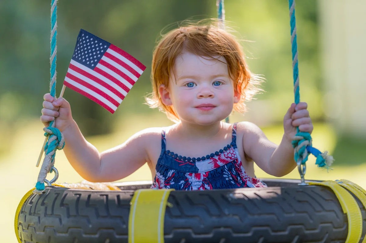 Two year old red-headed girl holding American flag