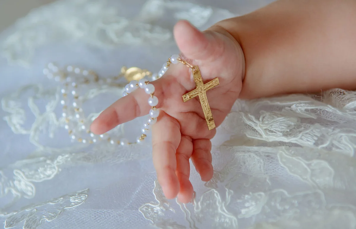 Child's hand with a crucifix