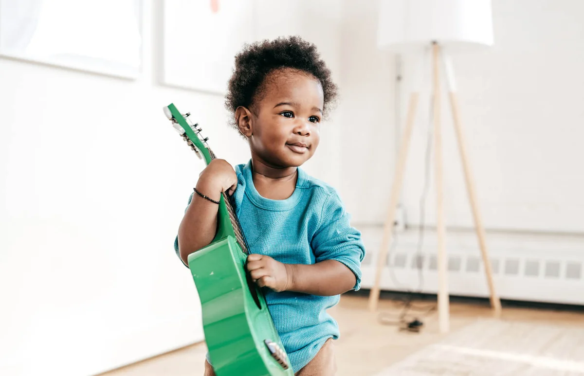 Toddler holding guitar