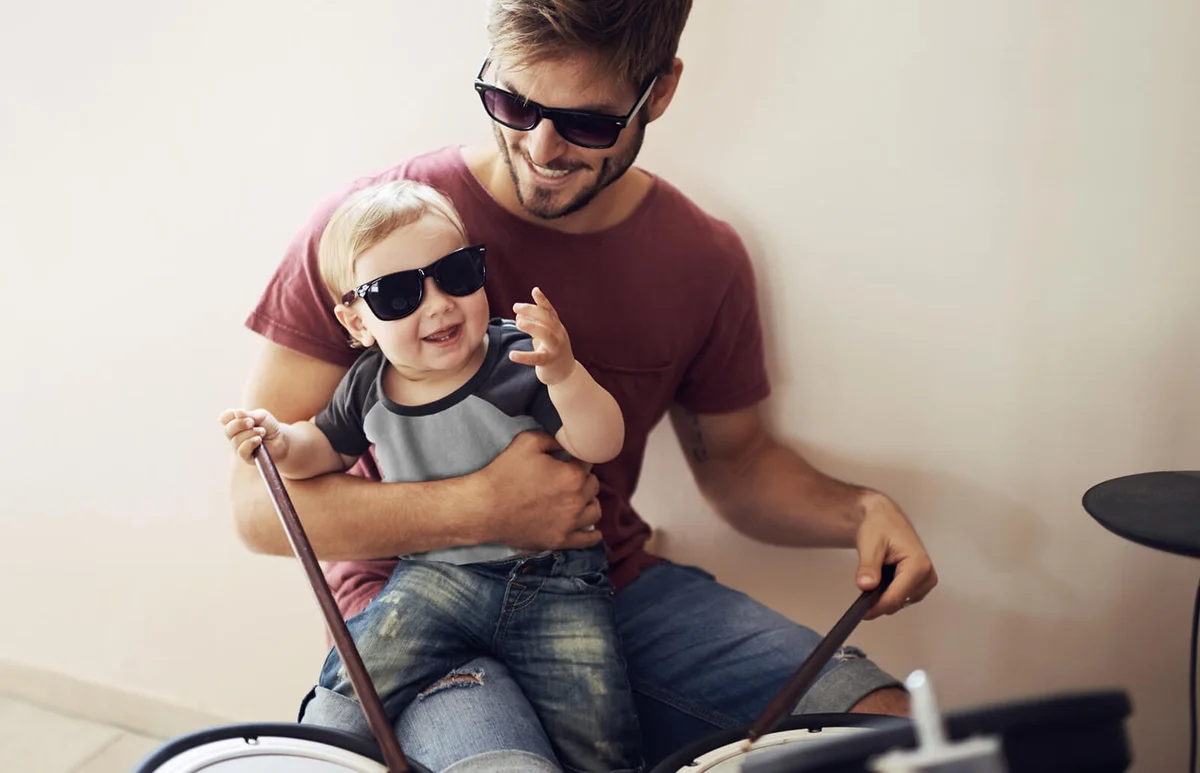 father teaching his young son to drum