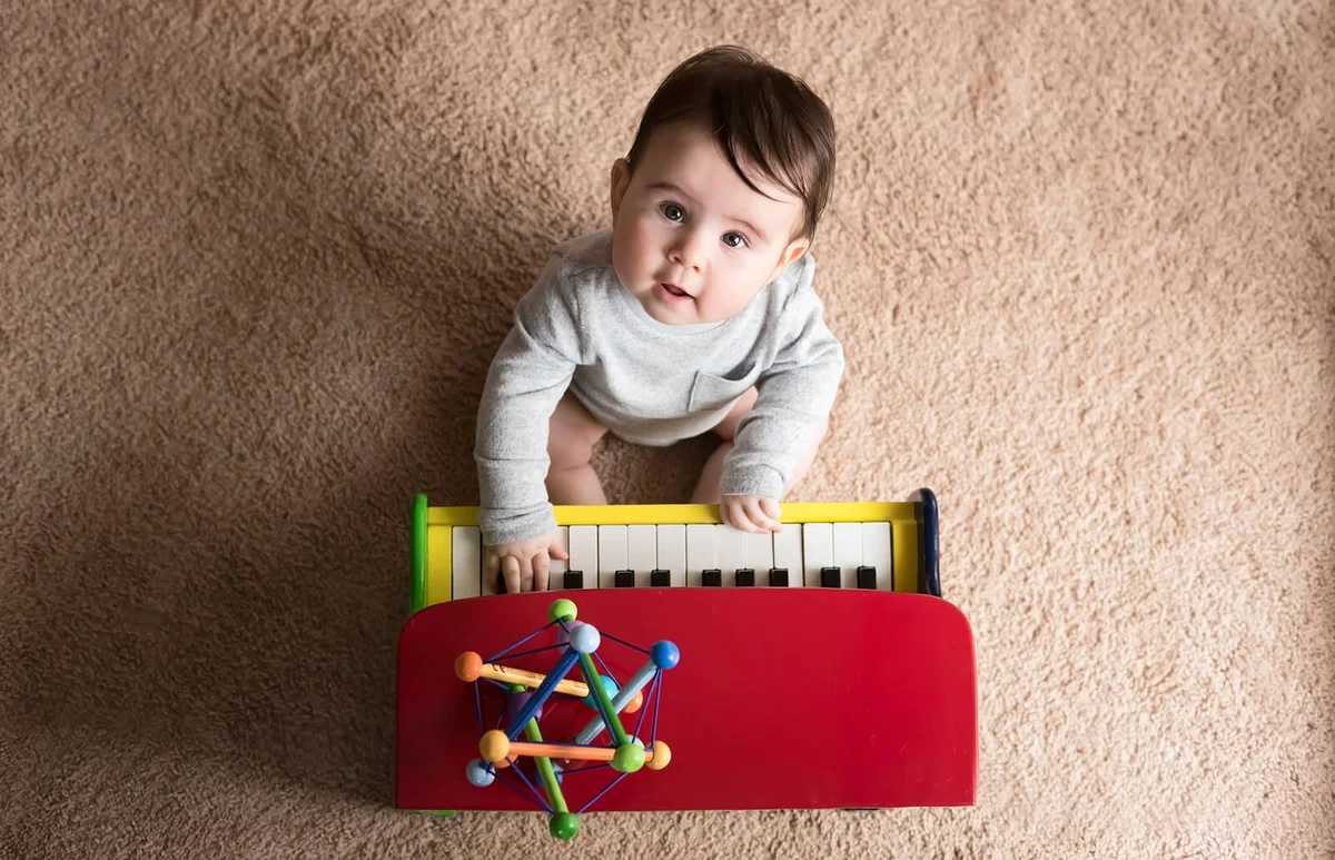 cute baby boy playing toy piano