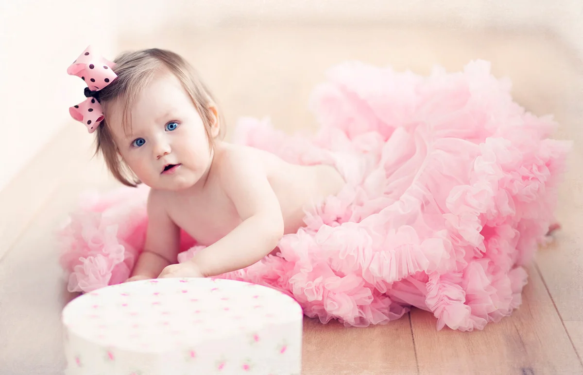 Baby girl in pink tutu skirt with pink hairband