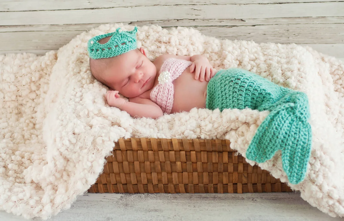 Newborn Baby Girl Wearing a Mermaid Costume Sleeping in Basket