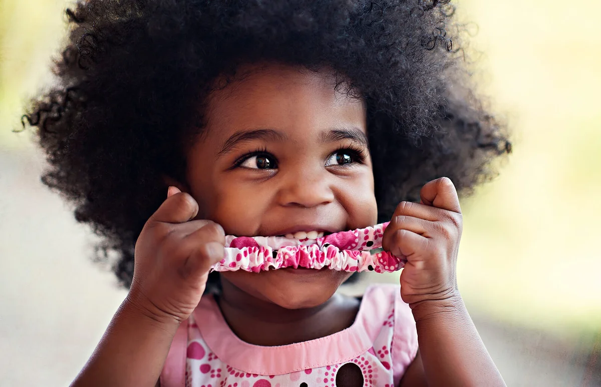 Happy Female Toddler with Afro and Hair Ribbon