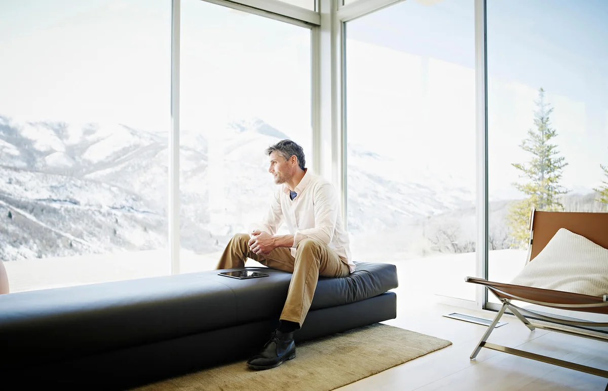 Man on couch in modern home with digital tablet