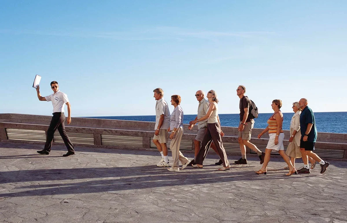 Group of tourists following male tour guide