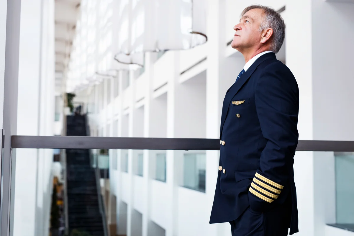 Senior pilot waiting at the airport lobby for flight