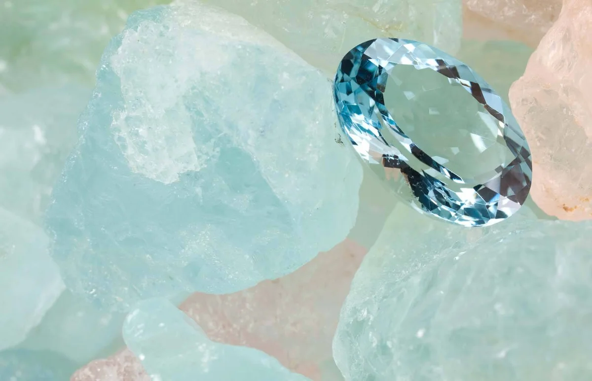 Polished aquamarine is on rough aquamarine gems