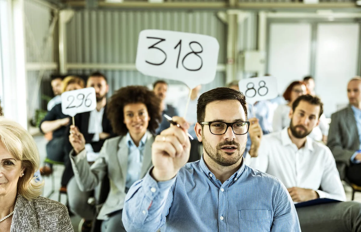 business people having an auction in a board room