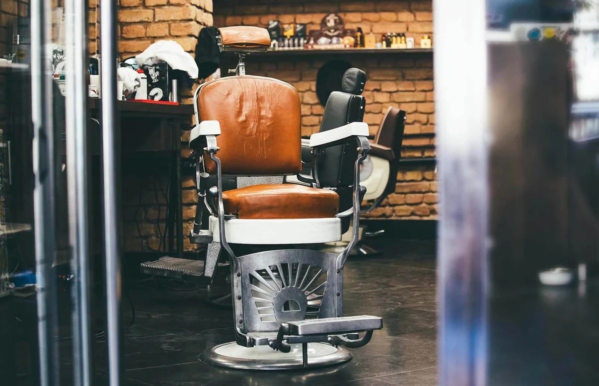 Stylish Vintage Barber Chair In brick wall Interior