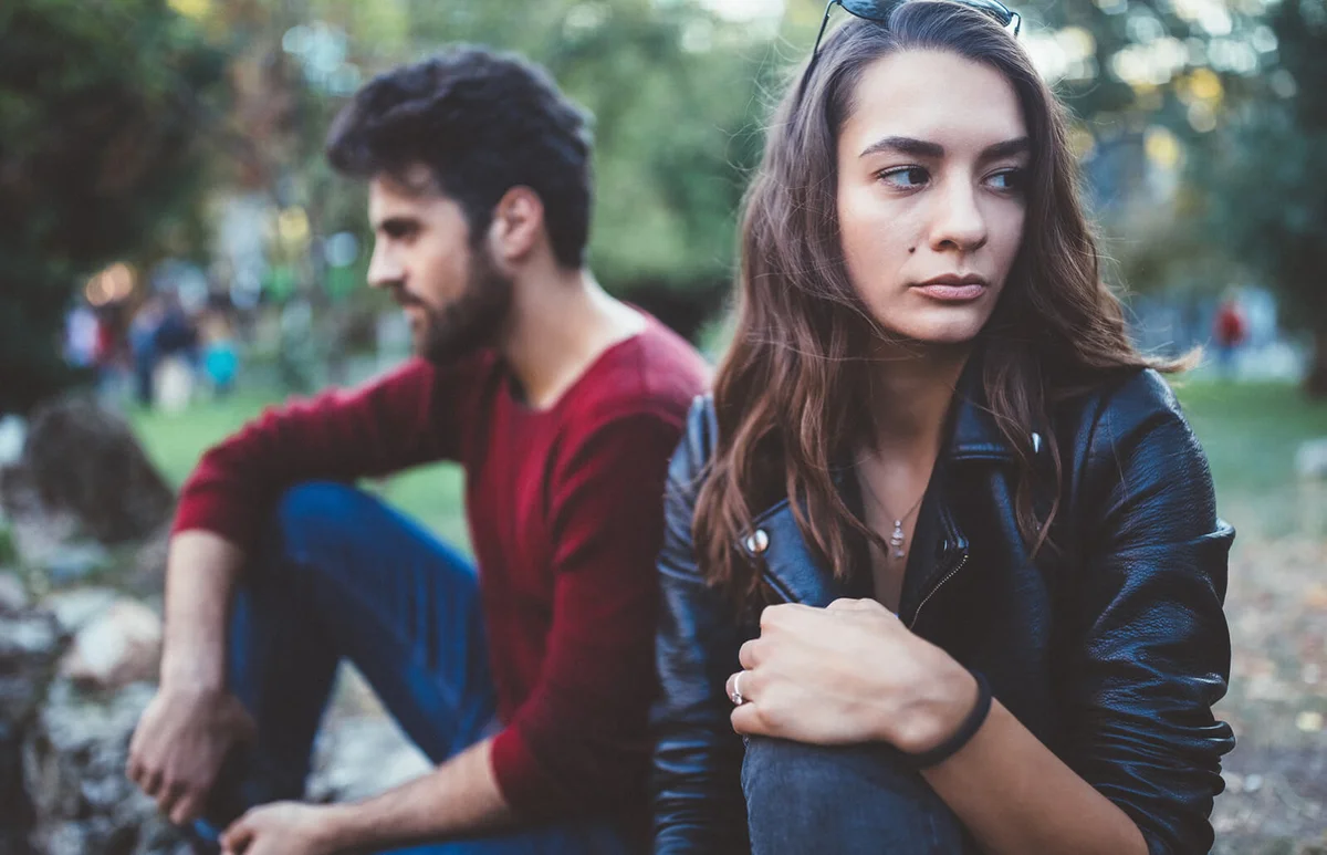 Young couple in the park feeling unhappy