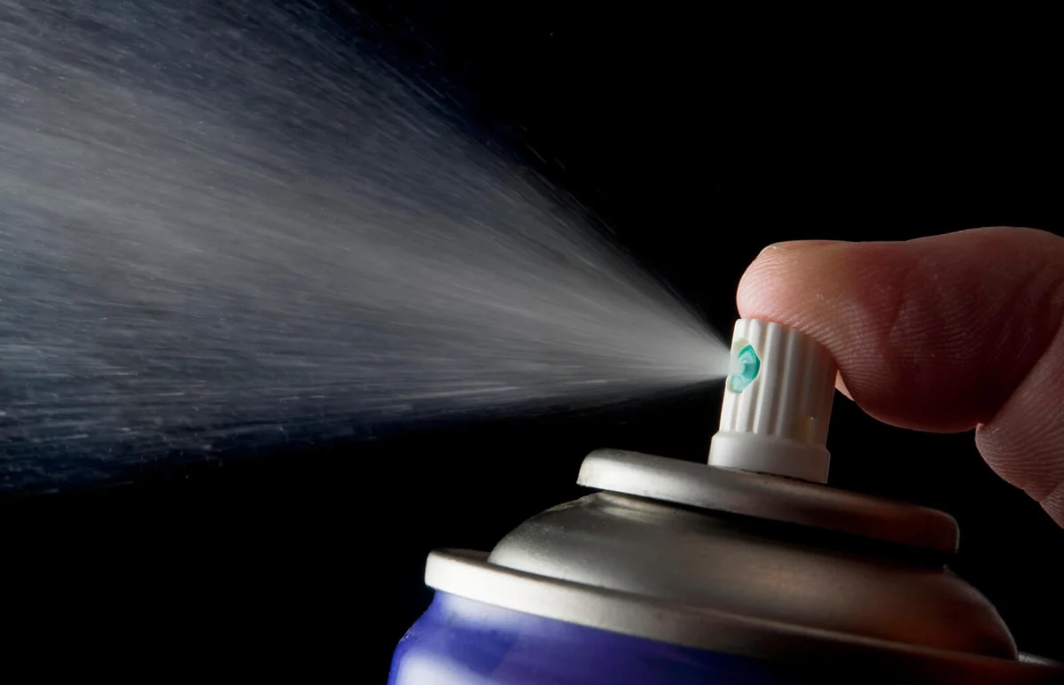 Spraying aerosol can isolated in black