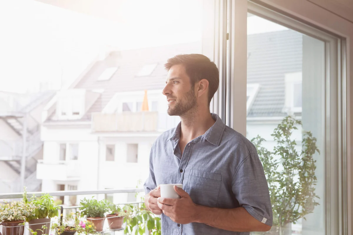 Smiling man looking out of window