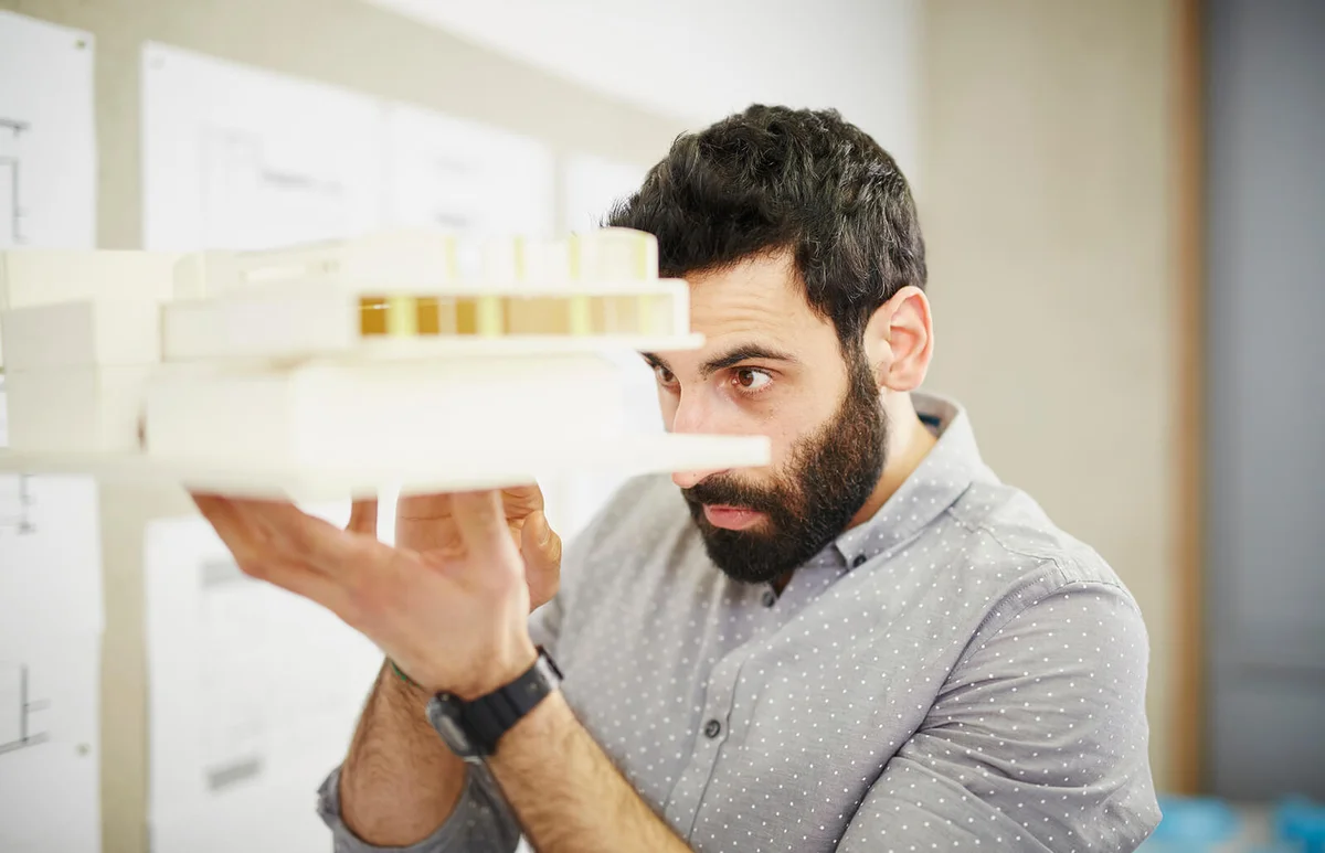Man architect looking at model