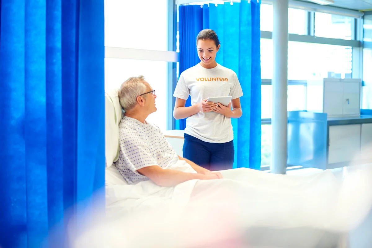 Young hospital volunteer with patient