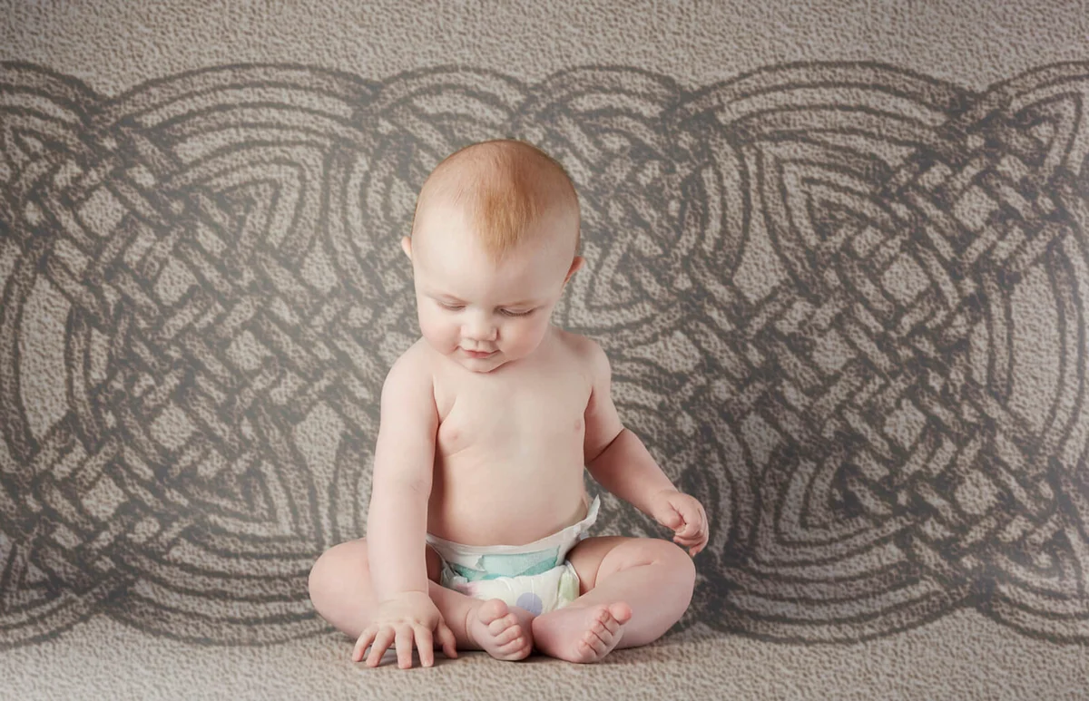 baby boy sitting up and touching floor