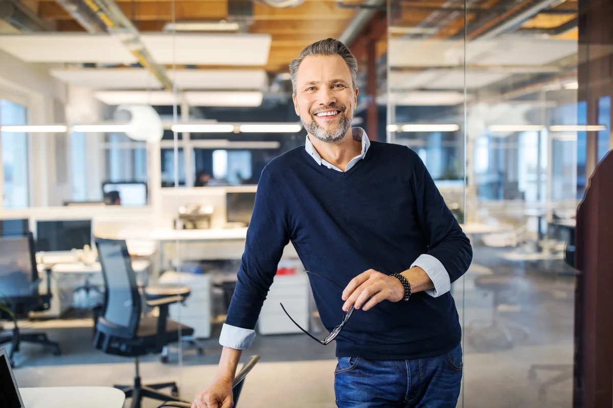 Successful mid adult businessman standing in office