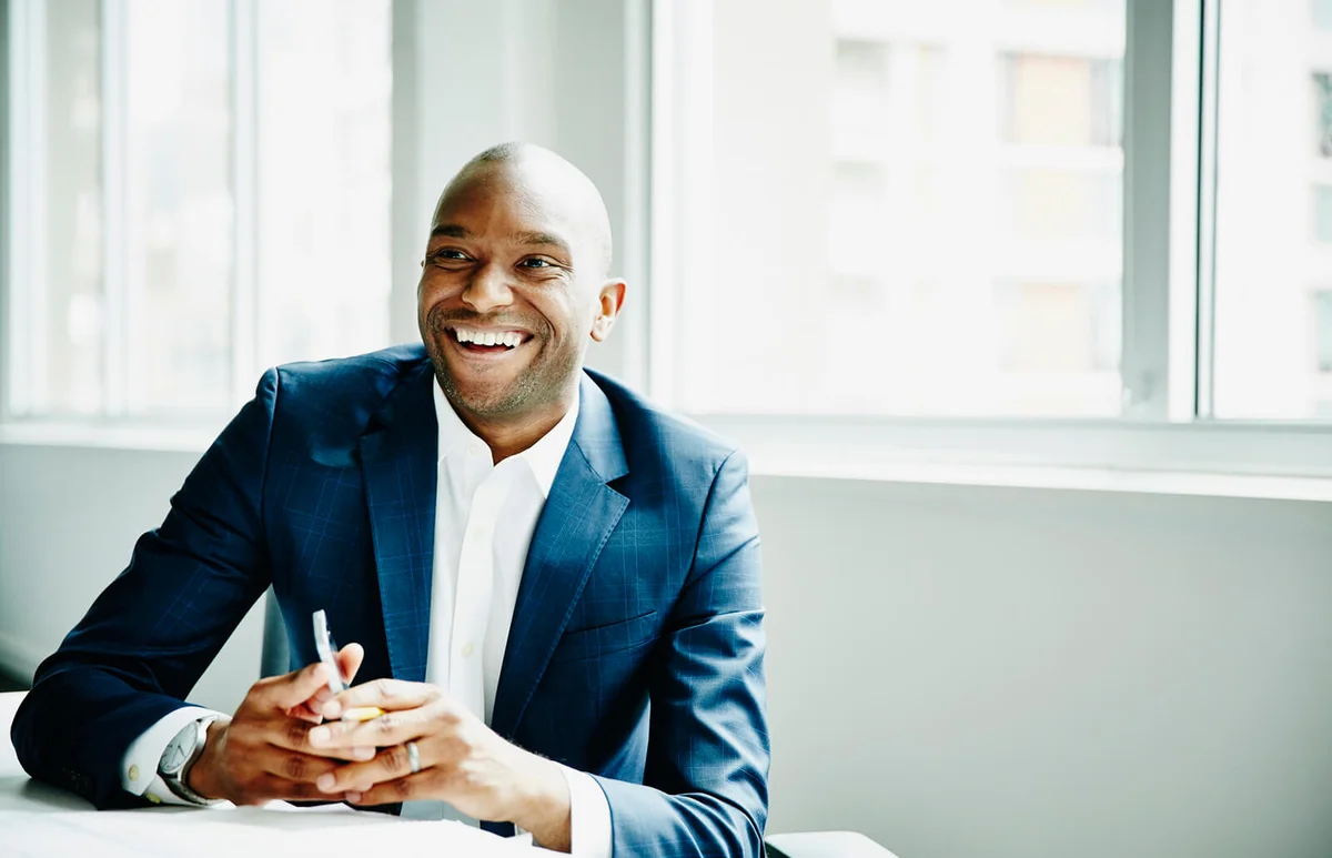 Smiling businessman in discussion at workstation
